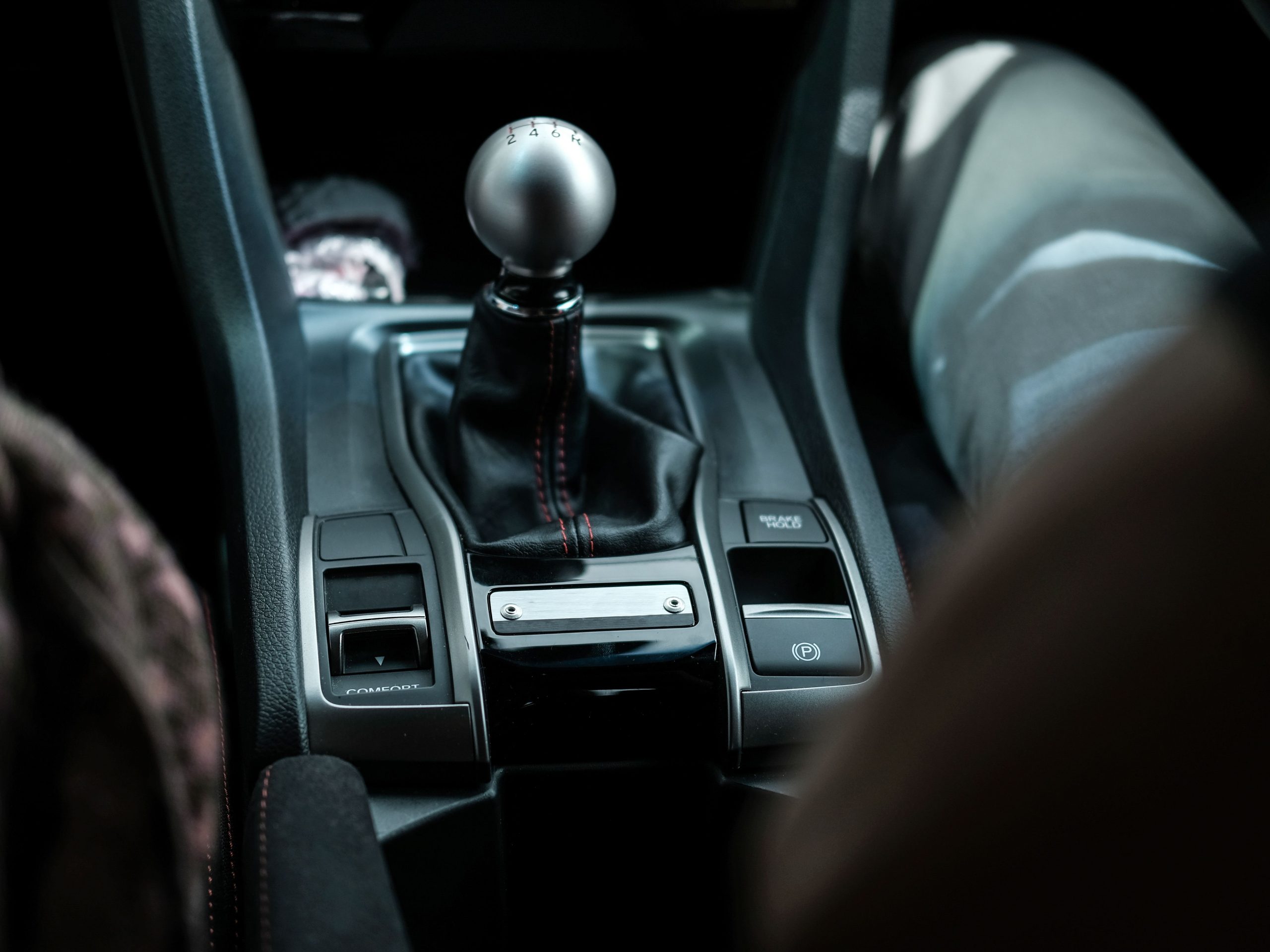 Closeup of a black modern manual car transmission gear shifter