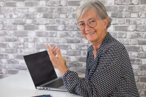 Smiling confident older business woman talking with collegue whi