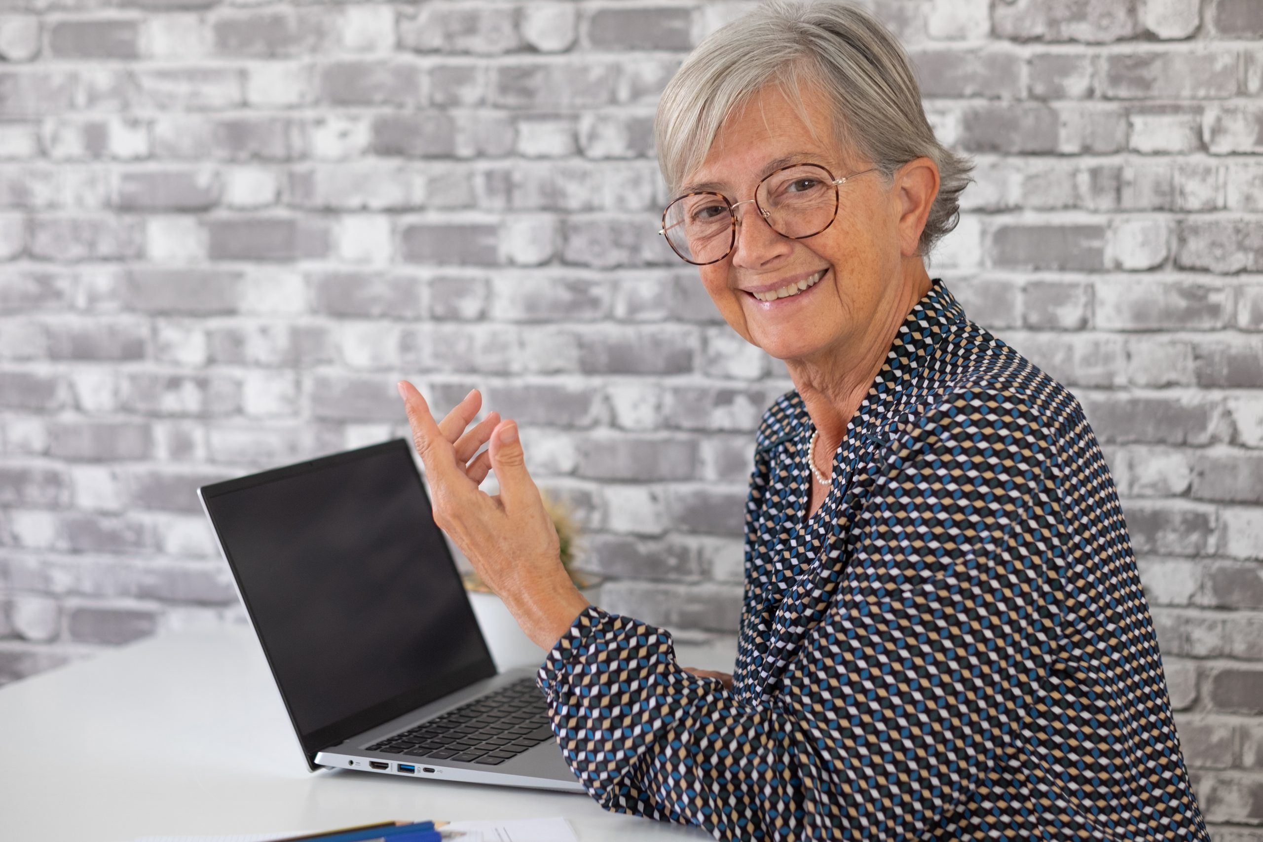 Smiling confident older business woman talking with collegue whi